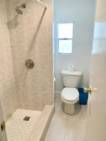 a swimming pool with outdoor seating and trees in the background