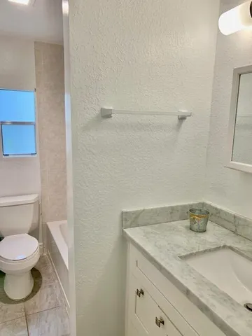 a white toilet sitting next to a bath tub and a shower