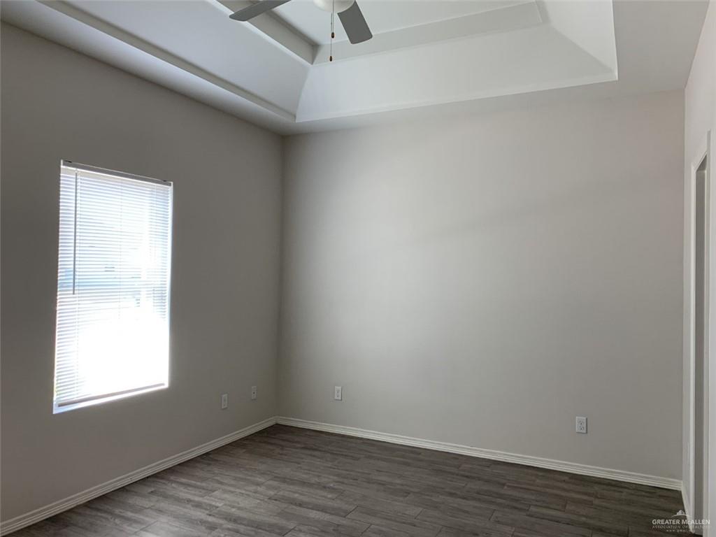 420 Teague Avenue, Unit 4 Edinburg, TX 78539 - Photo 7 of 14 an empty room with wooden floor and windows