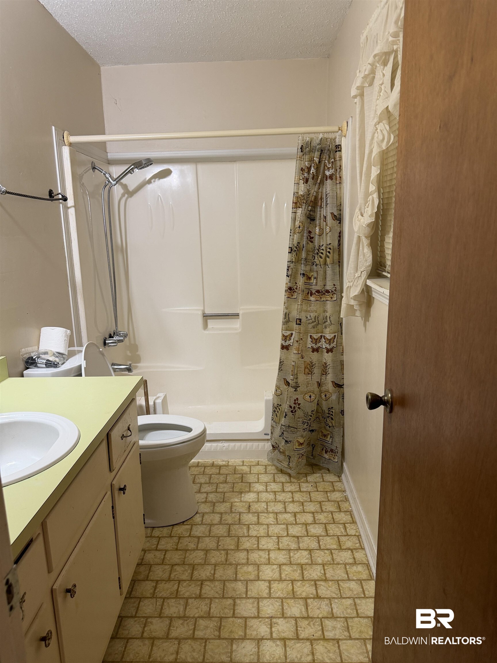 513 Club Wiley Road Jackson, AL 36545 - Photo 19 of 19 Primary Full bathroom with vanity, a textured ceiling, shower / bath combo, and brick patterned flooring