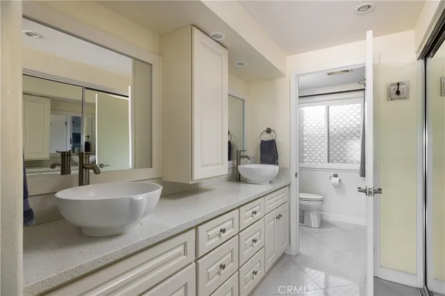 a spacious bathroom with a double vanity sink a mirror and a bathtub