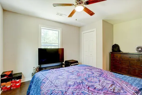 a bedroom with a bed and a flat tv screen on dresser