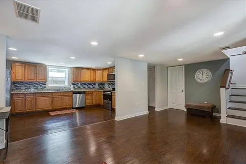 a view of kitchen with stainless steel appliances granite countertop a stove and a refrigerator