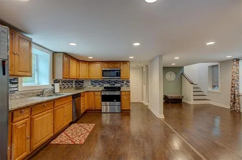 a kitchen with stainless steel appliances kitchen island granite countertop a stove a sink and a refrigerator