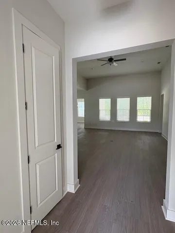 a view of a hallway with wooden floor and a cabinet