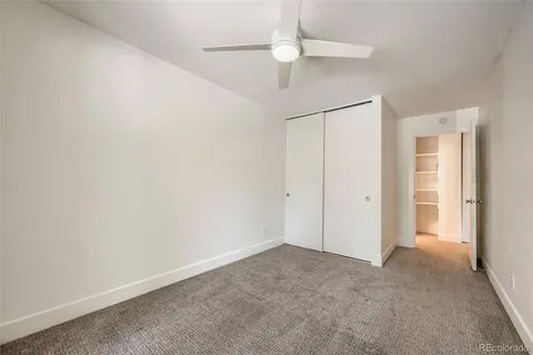 an empty room with windows and ceiling fan
