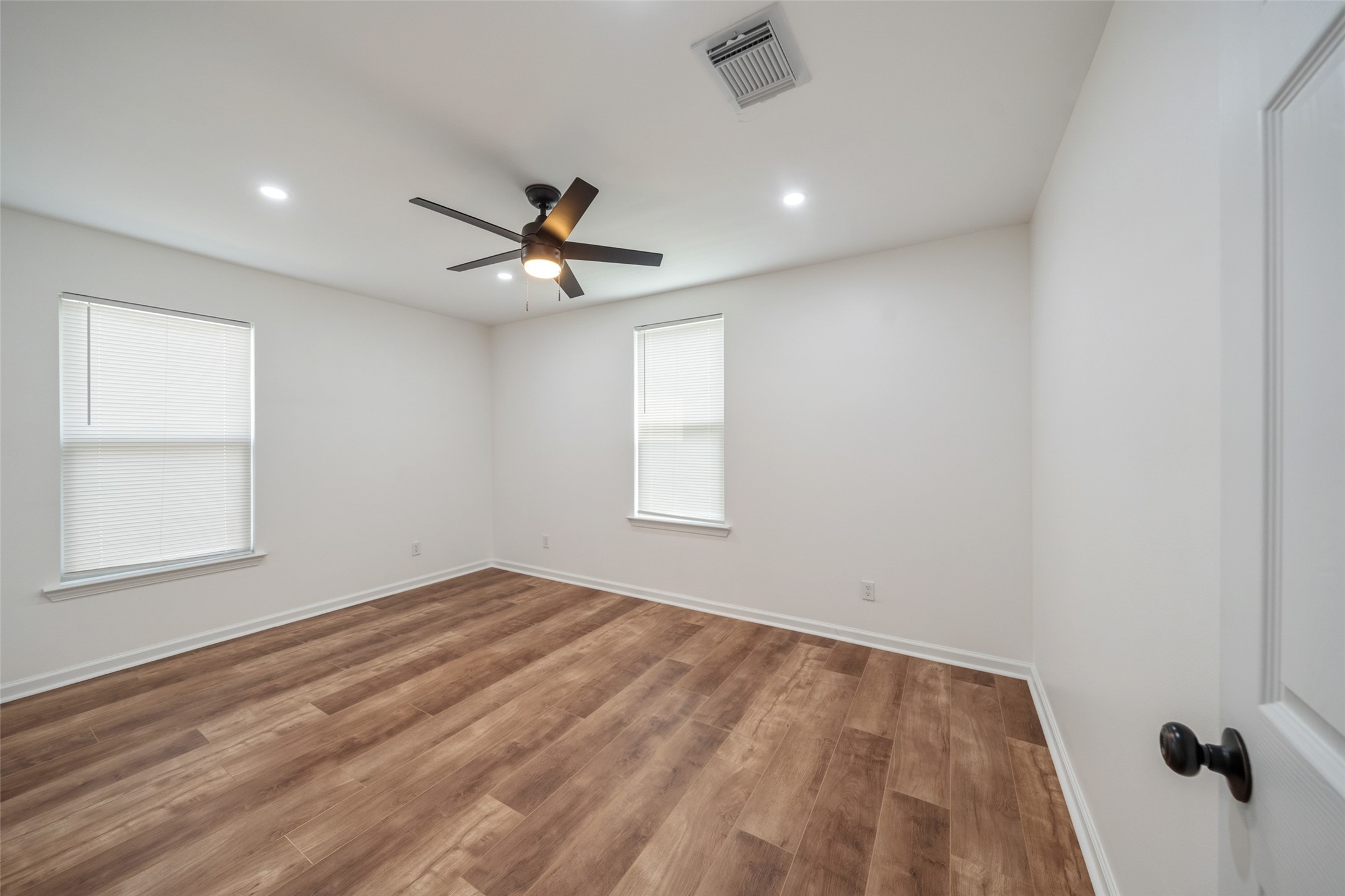 3051 Rothermel Road Houston, TX 77093 - Photo 18 of 24 Bright and inviting guest bedroom with a ceiling fan and sleek recessed lighting.
