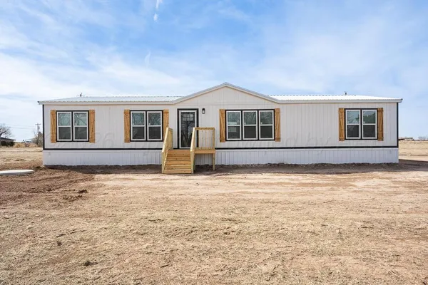 a kitchen with stainless steel appliances granite countertop a sink a stove a refrigerator and island with wooden floor