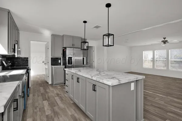 a view of a kitchen with wooden floor and a window