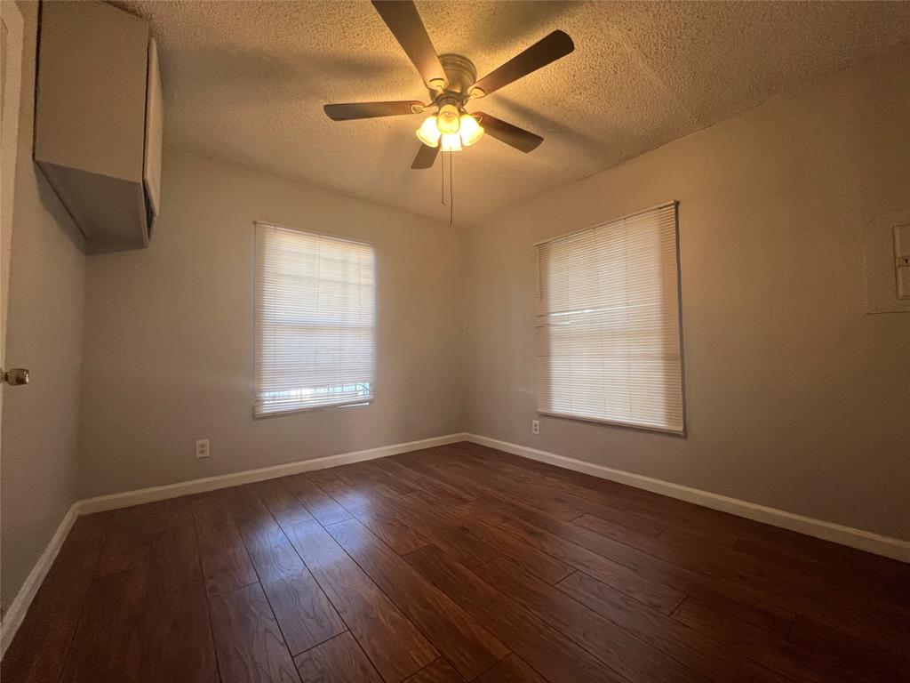 2722 Locust Avenue Dallas, TX 75216 - Photo 10 of 20 a view of an empty room with wooden floor and a window