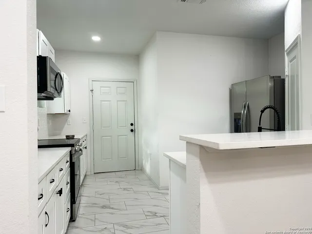 a kitchen with granite countertop a sink and cabinets