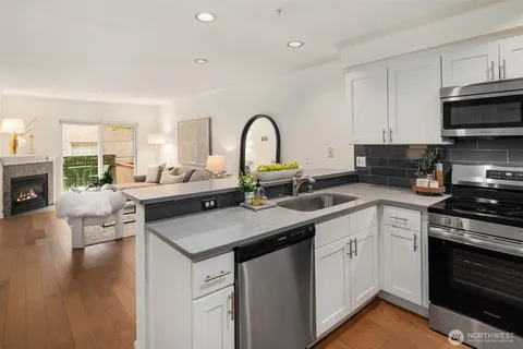 a kitchen with a sink white cabinets and appliances