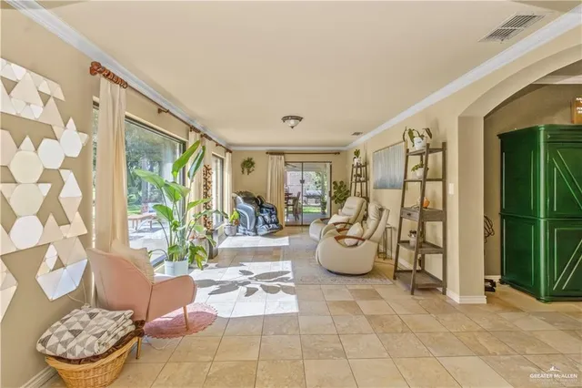 a living room with patio furniture and a potted plant