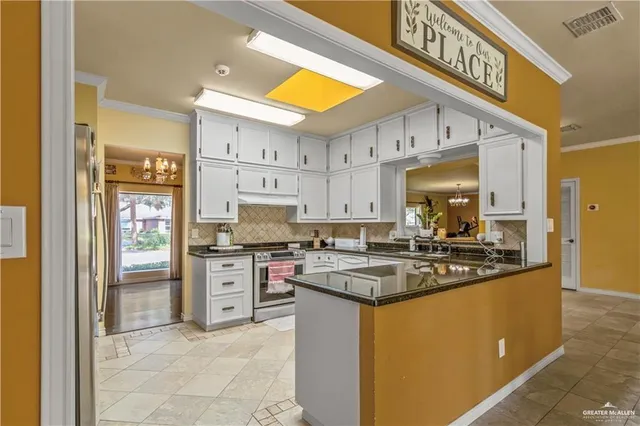 a kitchen with stainless steel appliances granite countertop a stove a sink and a refrigerator