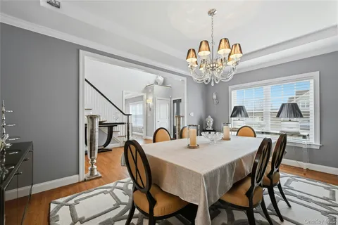 a view of a dining room with furniture a chandelier and wooden floor
