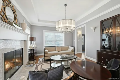 a living room with furniture a chandelier and a fireplace