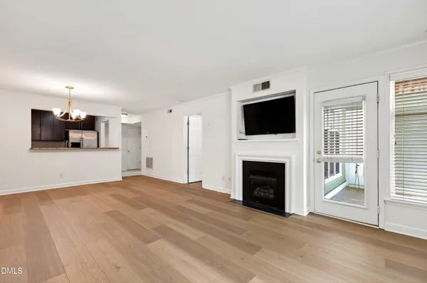 a view of a livingroom with a fireplace a flat screen tv and staircase