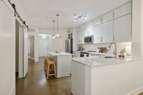 a kitchen that has a lot of cabinets and wooden floor
