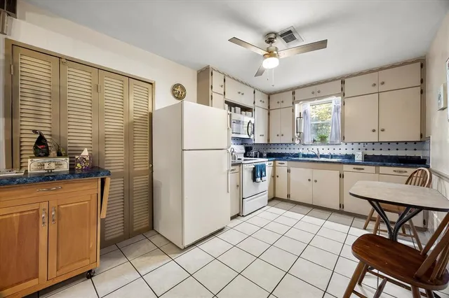 a kitchen with a refrigerator a sink dishwasher a stove and white cabinets with wooden floor