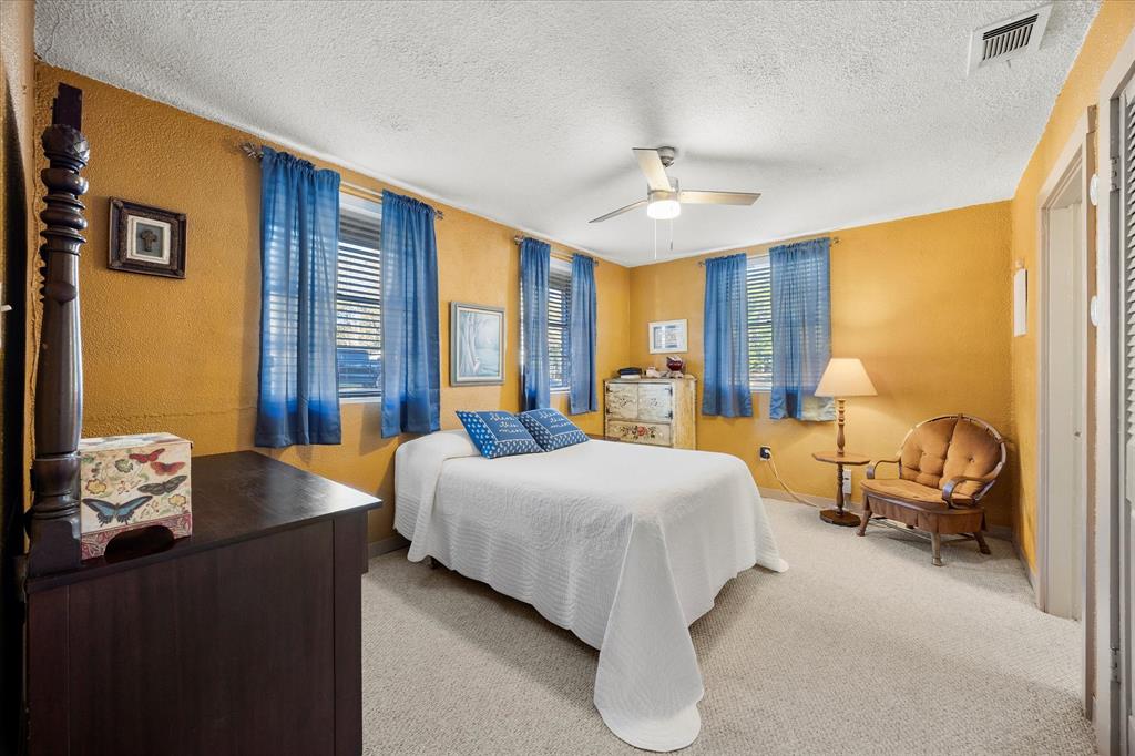 2097 County Road 3830 Quinlan, TX 75474 - Photo 15 of 38 a bedroom with a bed and large windows