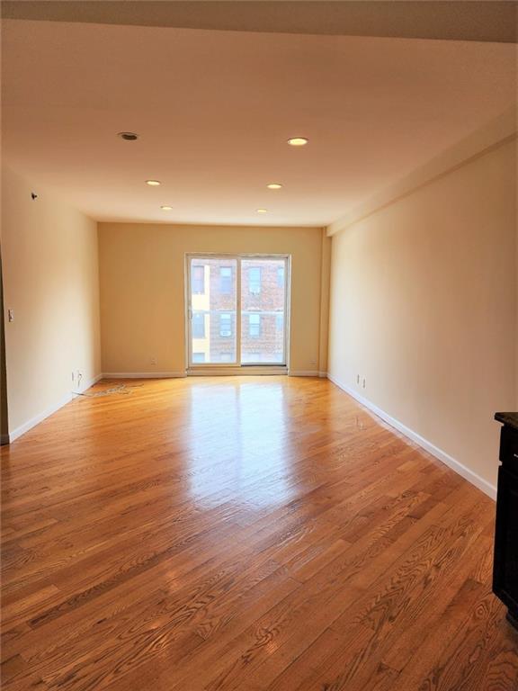2011 Avenue X, Unit 3A Brooklyn, NY 11235 - Photo 8 of 10 a view of an empty room with wooden floor and a window