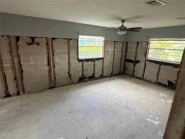 an empty room with windows and closet