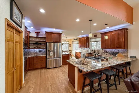 a kitchen with a refrigerator and a stove top oven