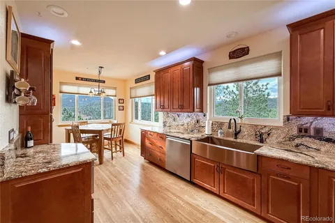 a kitchen with stainless steel appliances granite countertop sink stove top oven and cabinets