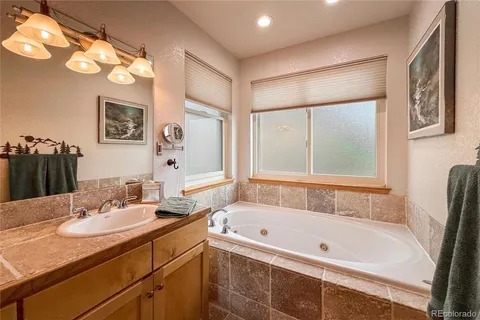 a bathroom with a tub sink and mirror
