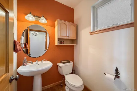 a bathroom with a toilet sink and mirror