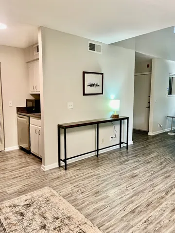 a view of a kitchen with wooden floor and electronic appliances