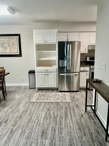 a kitchen with granite countertop a refrigerator and wooden floor