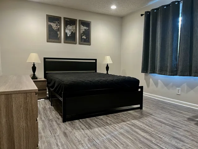 a bedroom with a bed and wooden floor