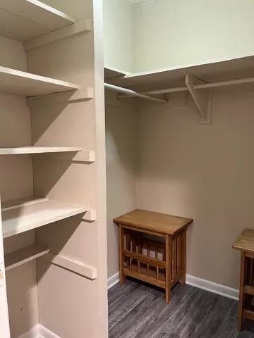 a view of walk in closet with clothes and shoes