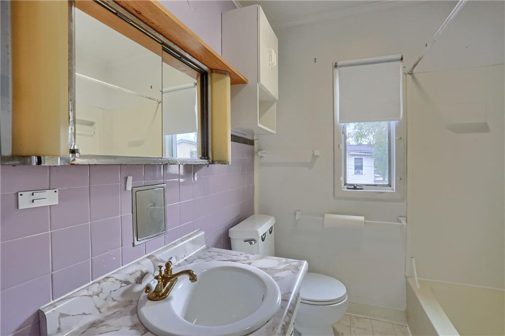 516 17th Street Beaver Falls, PA 15010 - Photo 19 of 28 a bathroom with a granite countertop toilet sink and mirror
