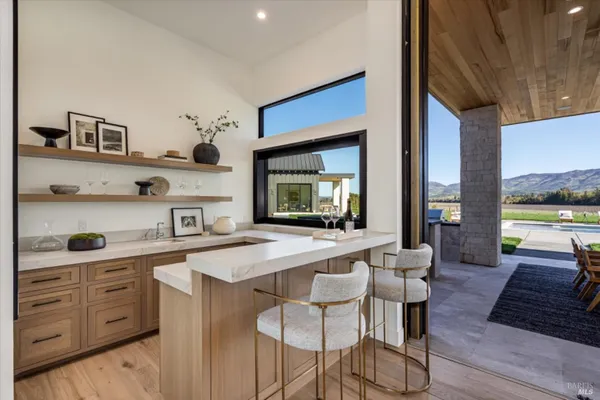 a living room with furniture kitchen view and a chandelier