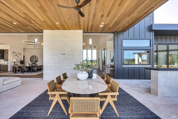 a dining room with furniture a floor to ceiling window and wooden floor