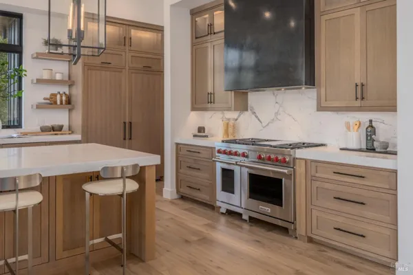 a large kitchen with kitchen island a large window in it