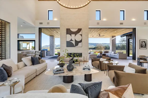 a living room with furniture kitchen view and a large window