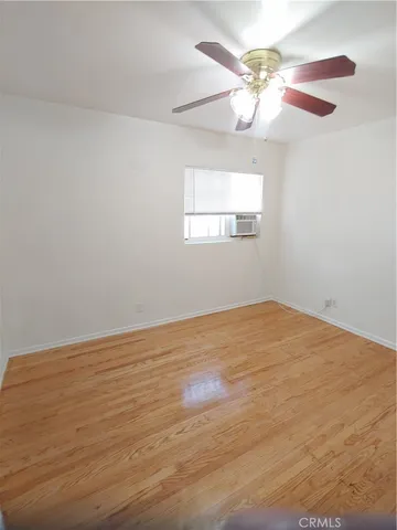a view of an empty room with a chandelier fan