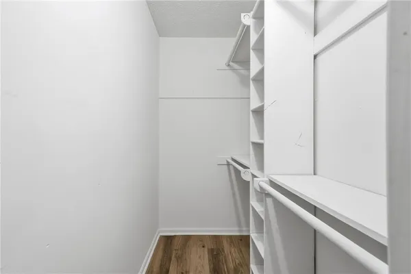 a view of walk in closet with empty racks