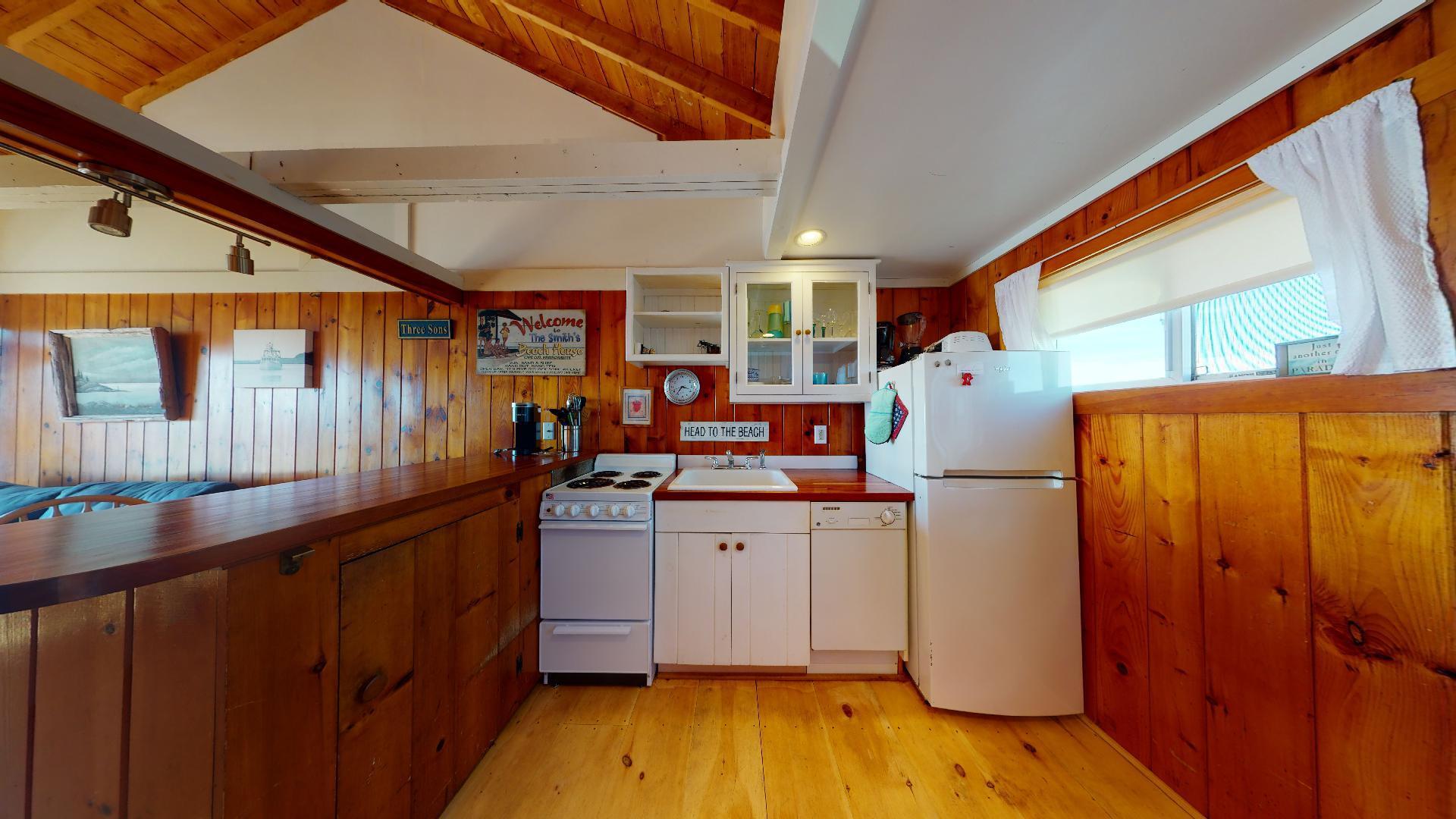 314 Shore Road, Unit 4 5 Truro, MA 02666 - Photo 13 of 50 a kitchen with sink a refrigerator and wooden cabinets