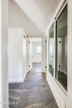 a view of a hallway with wooden floor and a living room