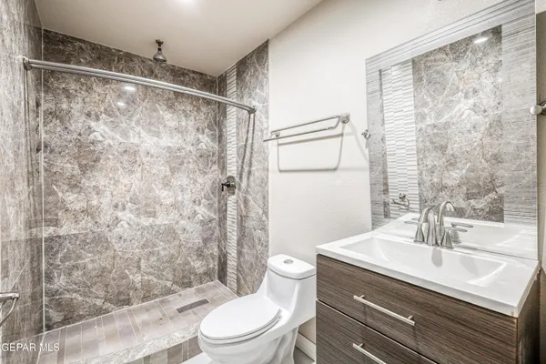 a bathroom with a sink a toilet and shower