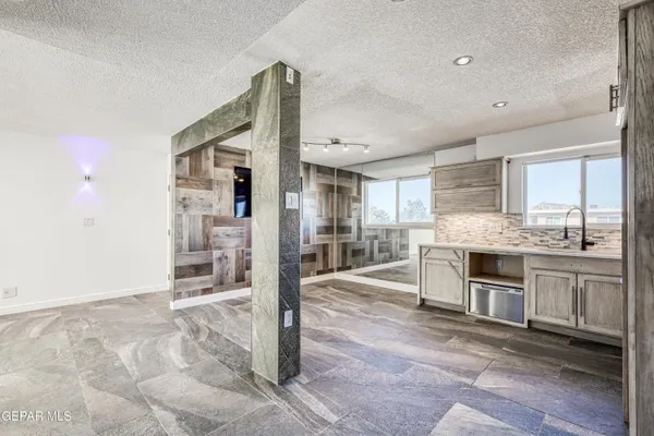 a large kitchen with stainless steel appliances kitchen island granite countertop a refrigerator and cabinets