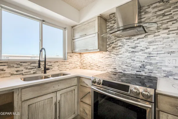 a kitchen with a sink stove and cabinets