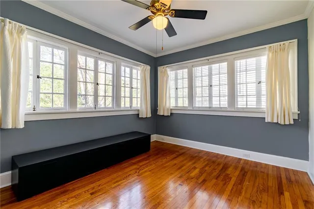 an empty room with wooden floor chandelier fan and closet area
