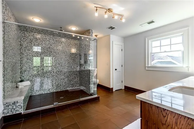a bathroom with a double vanity sink toilet and shower