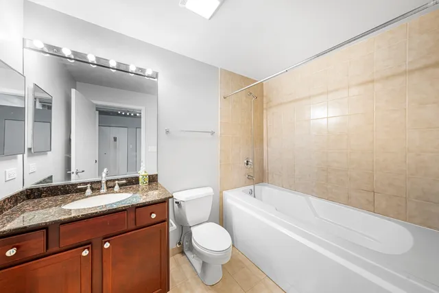 a bathroom with a granite countertop sink toilet and shower