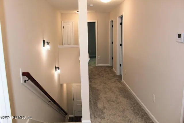 a view of an empty room with closet and a window